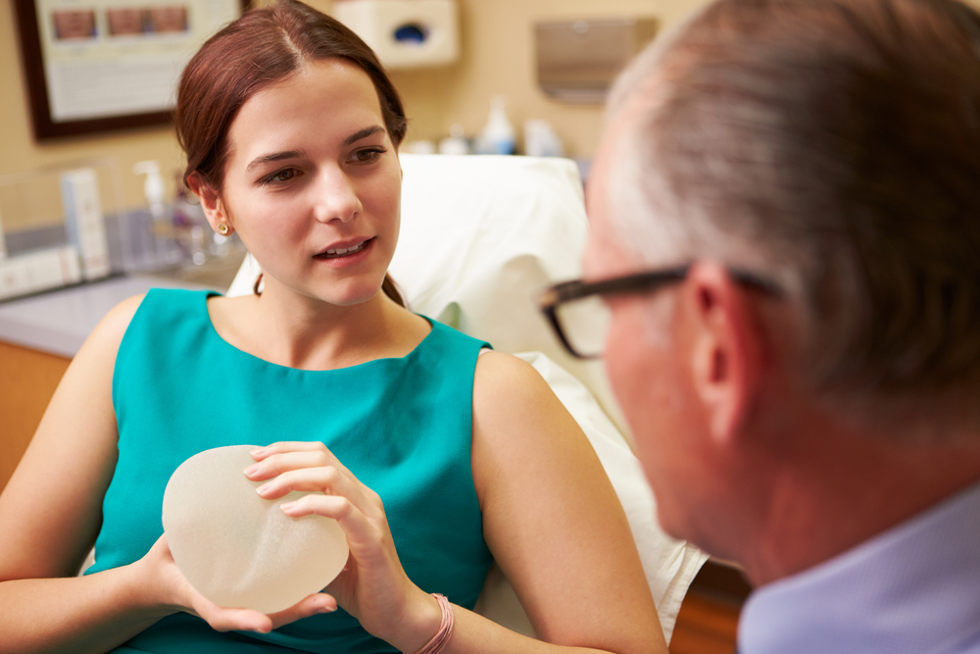 woman discussing breast enlargement finance with surgeon